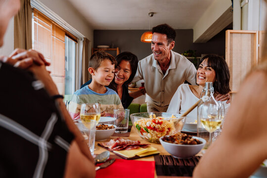 Family and friends reunion at home. Multigenerational family gathering enjoying a happy meal together