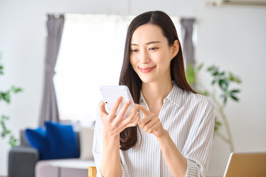電卓を操作して笑顔で計算する女性