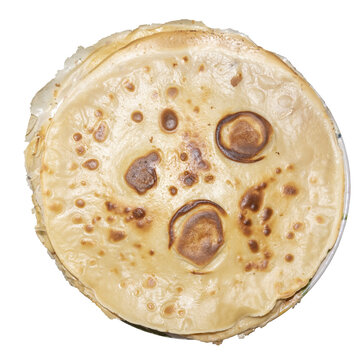 A pancake lies on a transparent background. The pancake has a smooth surface with a few brown spots where it has browned. It looks warm and ready to eat.