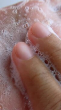 Rubbing hand cleansing soap foam slowly. Vertical close up view. Suitable for hand hygiene theme, daily wash routine, clean soft skin.