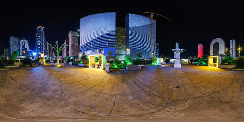 Obraz premium full seamless spherical night 360 panorama on square among modern glowing skyscrapers and office buildings in equirectangular projection, for VR AR content