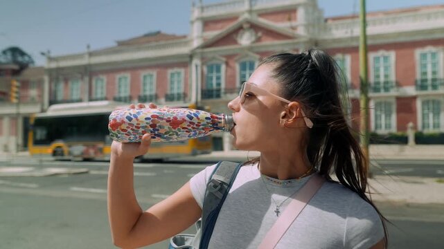 Young woman relaxing. Woman drinks from decorative bottle