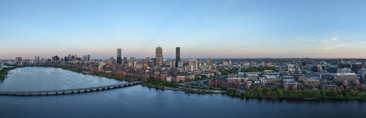 Naklejka premium Panoramic aerial view of Boston skyline and Charles River at sunset, USA featuring the Prudential and John Hancock towers above historic Back Bay and the calm Charles River
