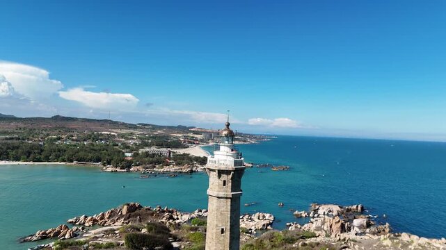 Title: Aerial orbit around Ke Ga Lighthouse with fishing boats and coastline in Vietnam