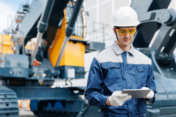 Service diagnostics and repair of hydraulic systems and hoses for industrial truck. Engineer worker uses computer tablet to configure equipment © Parilov