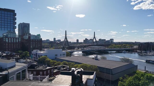 Beautiful view of Boston's I-93 Leonard P. Zakim Bunker Hill Bridge over the Charles River, featuring a boat cruising beneath the iconic cable-stayed structure.