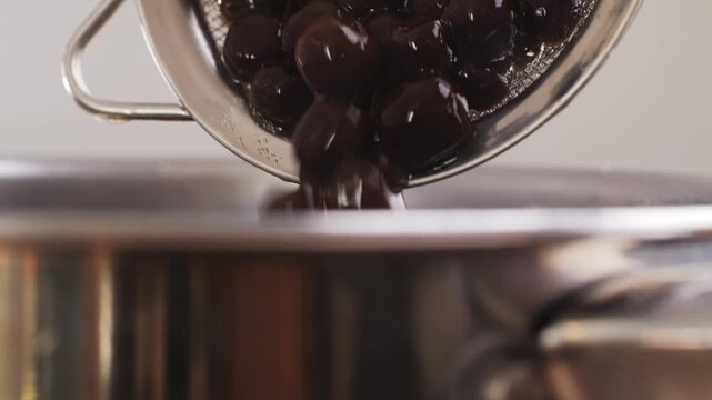 Cooking, boiling brown sugar flavor tapioca pearl balls, chinese food, ingredient of bubble tea, preparing food and drink, close up, recipe cookbook steps design concept.