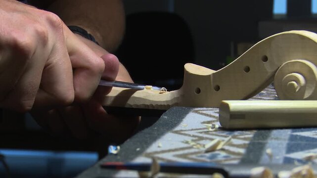 Bilbao, spain; may 21 2022: craftsman luthier carving a violin scroll
