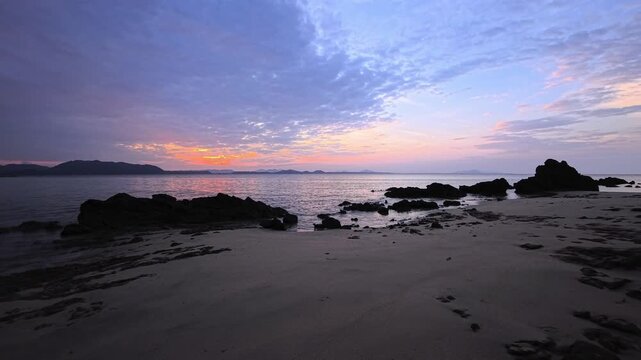 Sunset on a paradisiacal sandy and rocky beach on a tropical island in Thailand