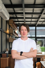 Obraz premium Serious Scandinavian business owner with crossed arms vertical format