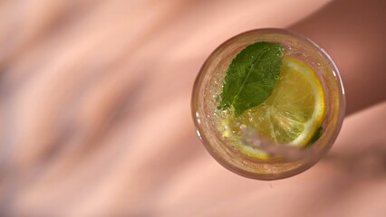 Top view of a refreshing drink with lemon slice, mint leaf and sparkling water bubbles. Concepts of summer drink, themes for bars, cafes, and restaurants, refreshment, beverage, health. © kinomaster