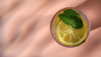 Top view of a refreshing drink with lemon slice, mint leaf and sparkling water bubbles. Concepts of summer drink, themes for bars, cafes, and restaurants, refreshment, beverage, health. © kinomaster