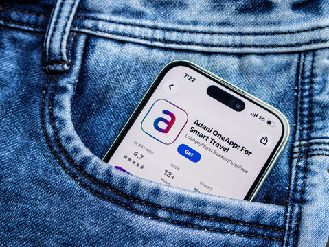 Smartphone with adani oneapp displayed on screen inside a blue denim jeans pocket