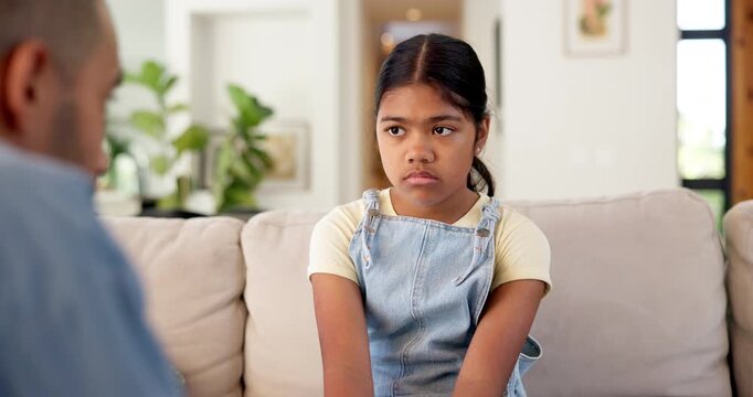 Sad, kid and father with lecture on sofa for bad behavior, discipline and agreement to warning. Lesson, strict dad and scolding unhappy child in home for teaching manners, explain rules and guidance