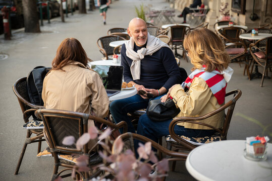 Grup of friends talking at a cozy outdoor cafe