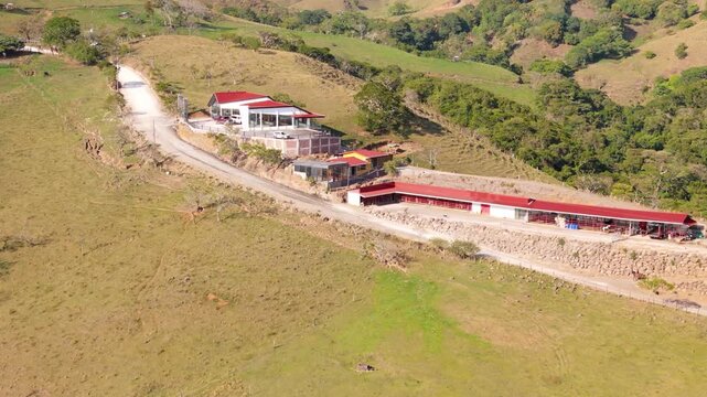 Aerial view approaching rural stables and property