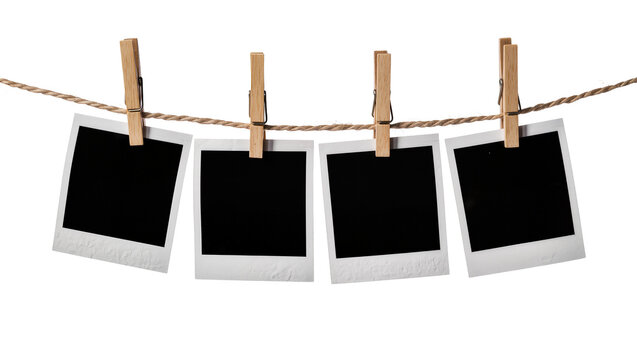 Four blank instant photo prints with wooden clothespins on a rope, isolated on transparent background