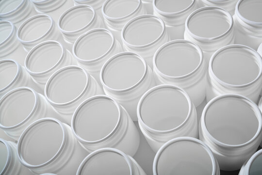 Large group of plastic bottles lined up on a table.