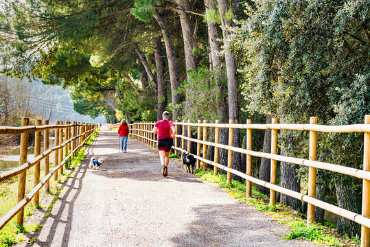 People walking and jogging along the path by the reservoir in the Sant Lloren&ccedil; de Montgai Nature Reserve, Noguera region, Lleida, Catalonia
