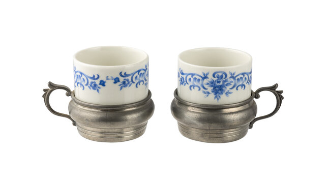 Old vintage craft porcelain tin set of two espresso coffee cups isolated on white. Ceramic and pewter coffee tableware.