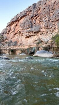 Flowing stream at Wadi Tanuf in Nizwa with clear water, rocks and canyon walls showcasing Omani valley nature. Nizwa, Oman - May 4 2026