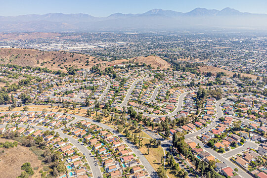 Pomona, California August 14, 2024: High Aerial City View toward Pomona Mountain Village Community around Stagecoach Dr, Village Loop Rd, Mill Valley Rd with Homes, Houses, Streets, Mountain 
