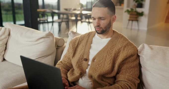 Reading, remote work and man with laptop on couch, wireframes planning and website upgrade proposal. Serious, freelance and web designer with pc for domain maintenance, home and homepage optimization