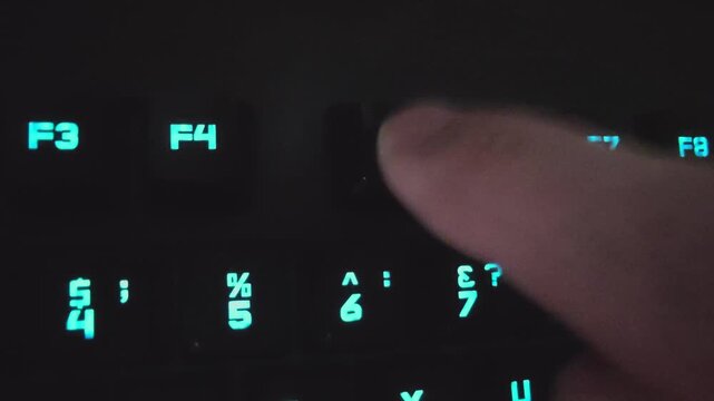 Close-up of a hand pressing the F4 key, followed by the F5 key on a backlit keyboard, showcasing the progression of actions in a digital environment