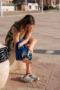 Woman with bionic leg cleaning prosthetic limb