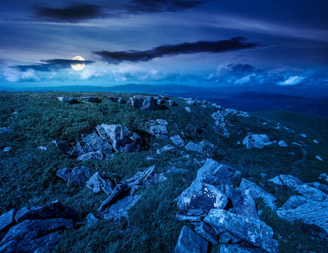 alpine grassy meadow at night. full moon over carpathian mountains landscape with huge boulders. alpine nature scenery of ukraine highlands in summer. mysterious view of remote place in mountains