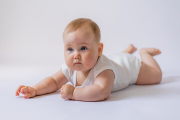 Fototapeta premium baby is lying on a bright blanket with a rattle
