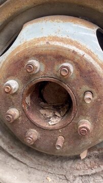 Rusty vehicle wheel hub with corroded bolts close-up detail shot