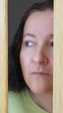 Woman spying and entering through the door as concept of nosy woman