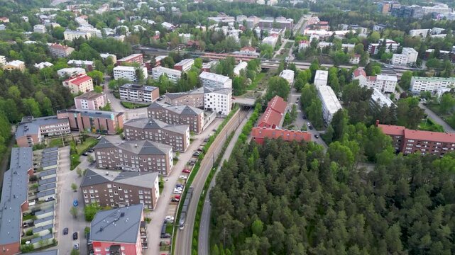 Aerial or cinematic footage of the Pohjois-Haaga and Pikku Huopalahti train station area in Helsinki, Finland.