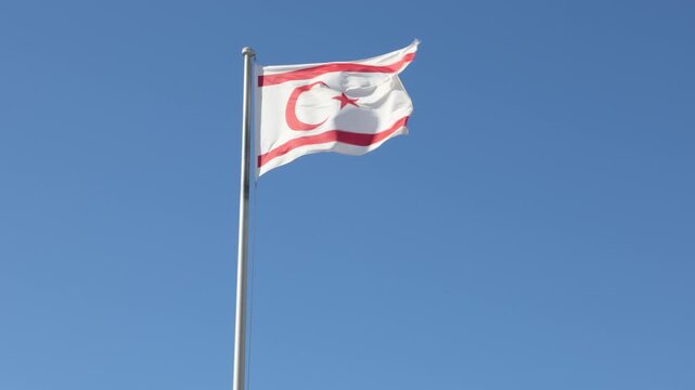Turkish Republic of Northern Cyprus Flag waving in blue sky. Northern Cyprus.