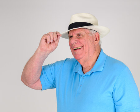 Man tips his Panama straw hat with a black band
