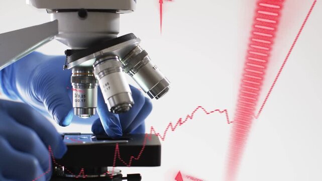 Gloved hand positioning slide on microscope in lab, nudging stage while red arrows rising for study