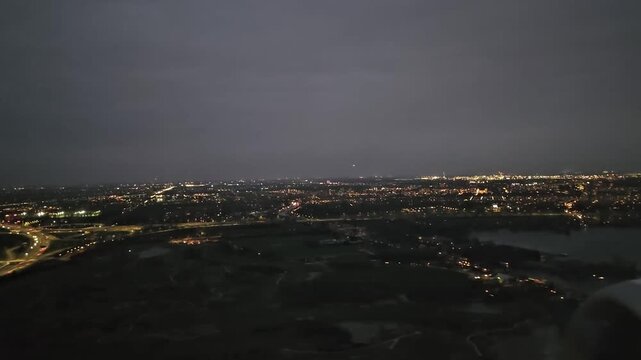 A plane approaches Schiphol Airport. A view of Amsterdam in the late evening. 
