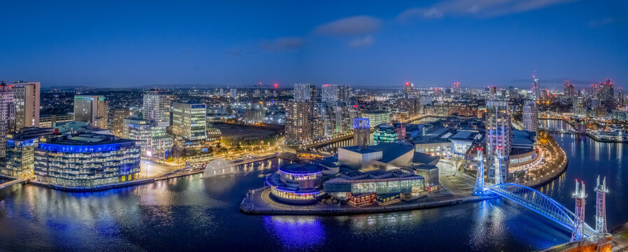 Salford Quays in Manchester, England, UK, aerial view of the waterfront district with MediaCityUK, modern architecture, illuminated buildings and docklands at dusk.