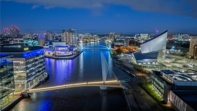 Salford Quays in Manchester, England, UK, aerial view of the waterfront district with MediaCityUK, modern architecture, illuminated buildings and docklands at dusk.