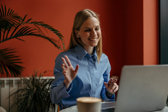 Woman making video call while working remotely in cafe
