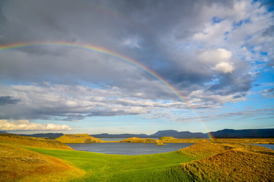 Rainbow arching over pseudocraters and lake