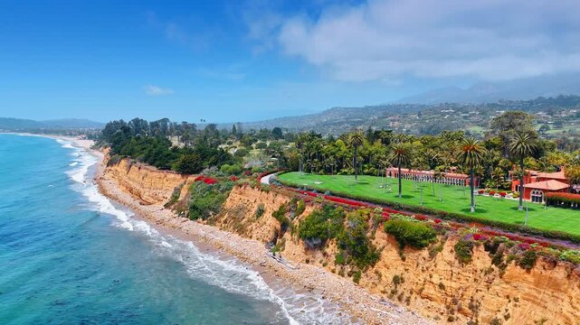 Popular scenic shoreline with cliffside views. Butterfly Beach in Montecito area of Santa Barbara, California, USA. Drone footage.
