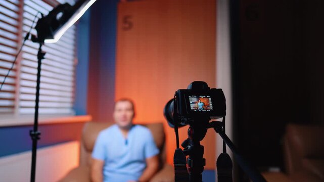 Professional medic speaks to camera in the light of soffit. Creating a video for medical blog.
