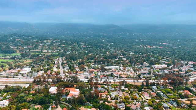 Scenic view on the vast green cityscape of Santa Barbara, California, USA. Haze covers the panorama and mountains in the backdrop.