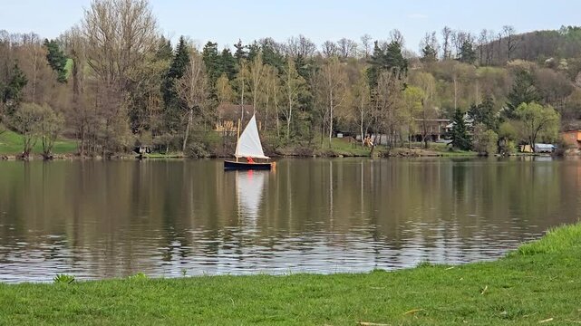 Small Sailboat on a Calm Lake with Mirror Reflection