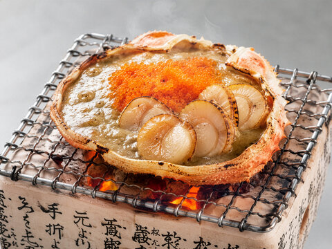 A close-up shot of  Kani Miso Yaki with Hotate on Hida Konro Grill.