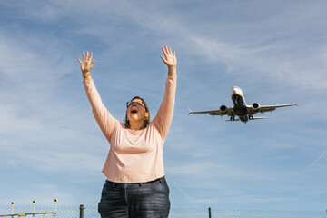 Woman celebrating joyful arrival watching airplane landing © Jordi Mora