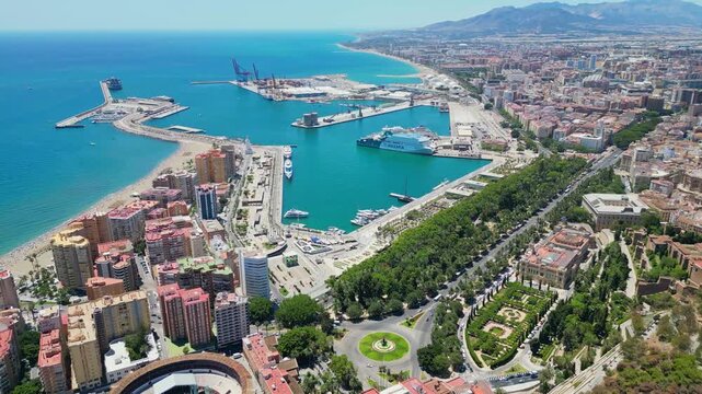 Malaga, Spain - July 17, 2025 High angle flyover of Malaga harbor and the historic Gibralfaro medieval fortress on the hilltop. Scenic coastal cityscape with luxury boats and Mediterranean sea in Anda