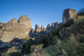 Meteora Greece rocky landscape with village and rock formations under clear sky © Tomas Bazant